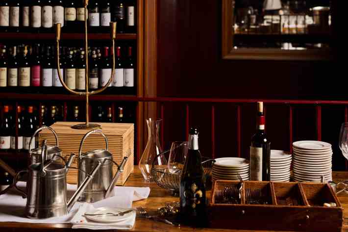 Wine bottles, plates, and glassware arranged on Babbo’s second-floor service table.
