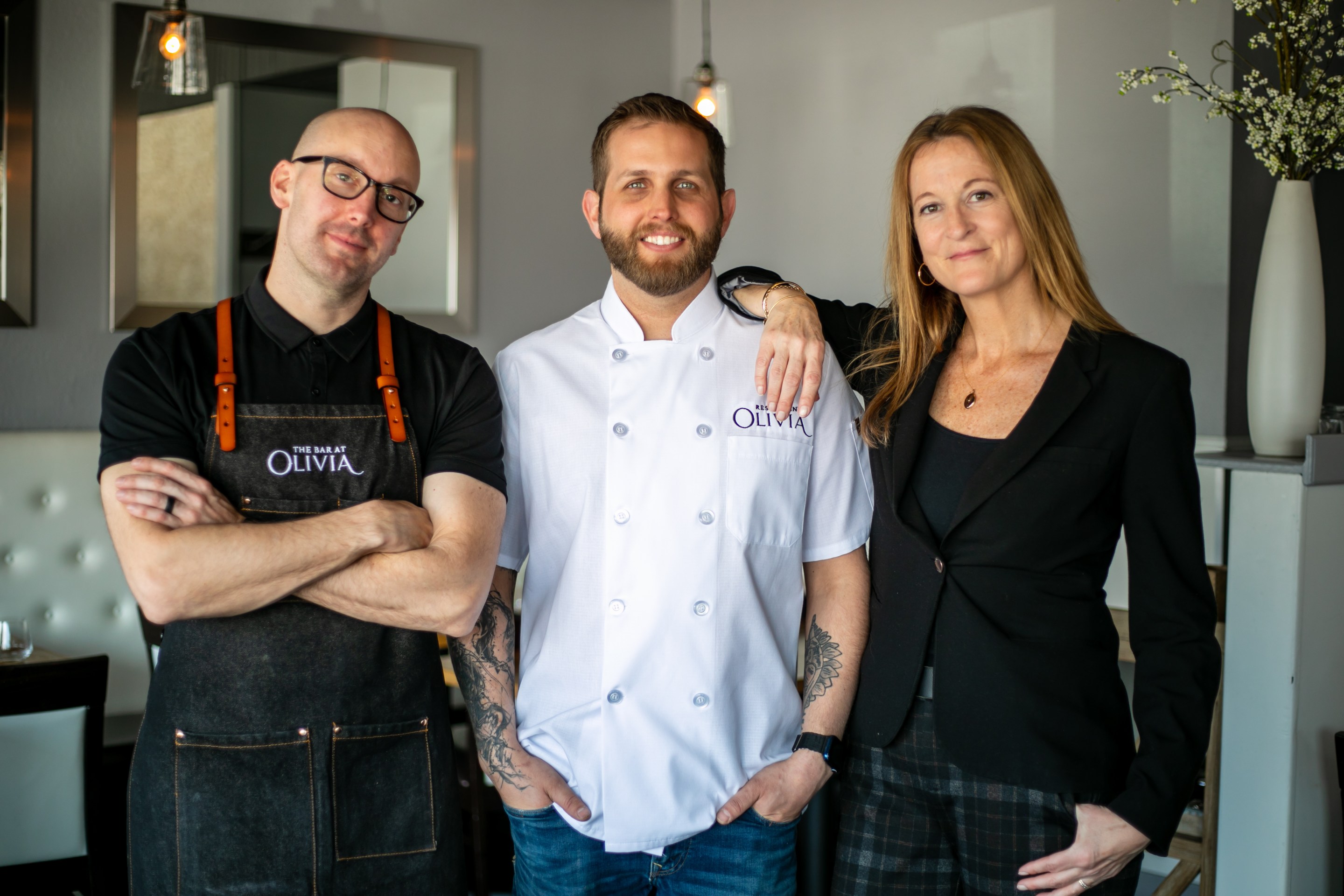Austin Carson, Chef Ty Leon, and Heather Morrison standing inside Dear Emilia restaurant