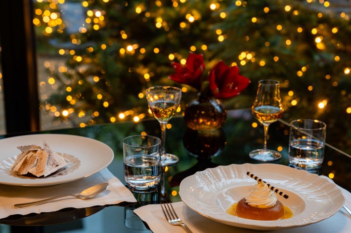 Italian dessert and digestivo at Portrait Milano restaurant with holiday lights in background.