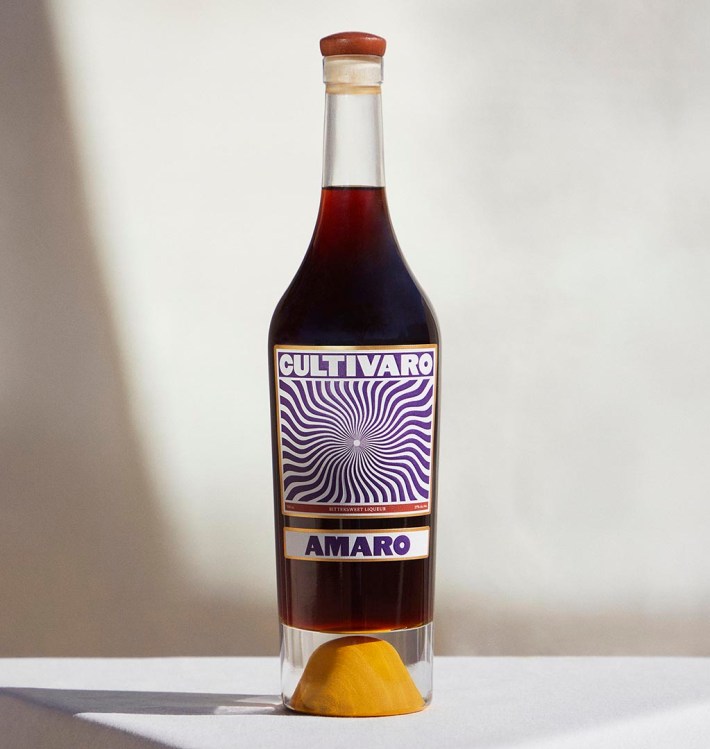 Bottle of Cultivaro Amaro displayed on a table with a graphic purple label.