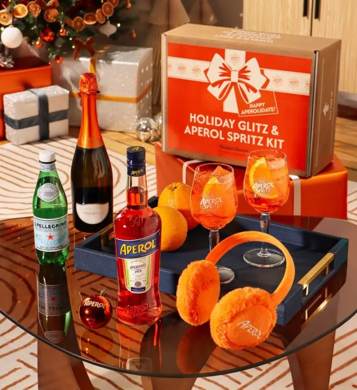 Aperol Spritz holiday kit with Prosecco, San Pellegrino, glasses, and orange accessories.