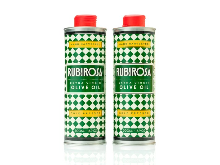 Two matching tin canisters of Rubirosa extra virgin olive oil with green-and-white patterning.