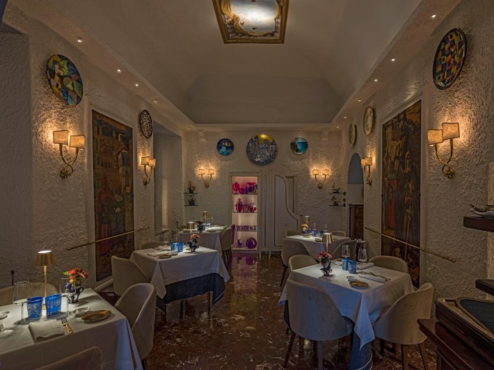 Interior dining room at La Caravella featuring artwork and the Andy Warhol Lounge.