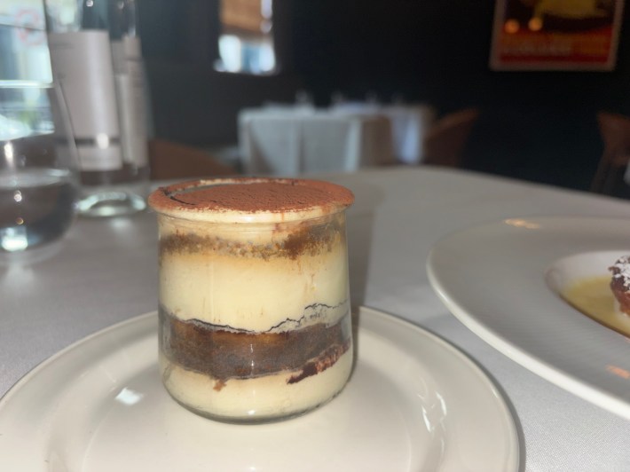 Glass jar tiramisu on a white tablecloth at Aqua e Vino.
