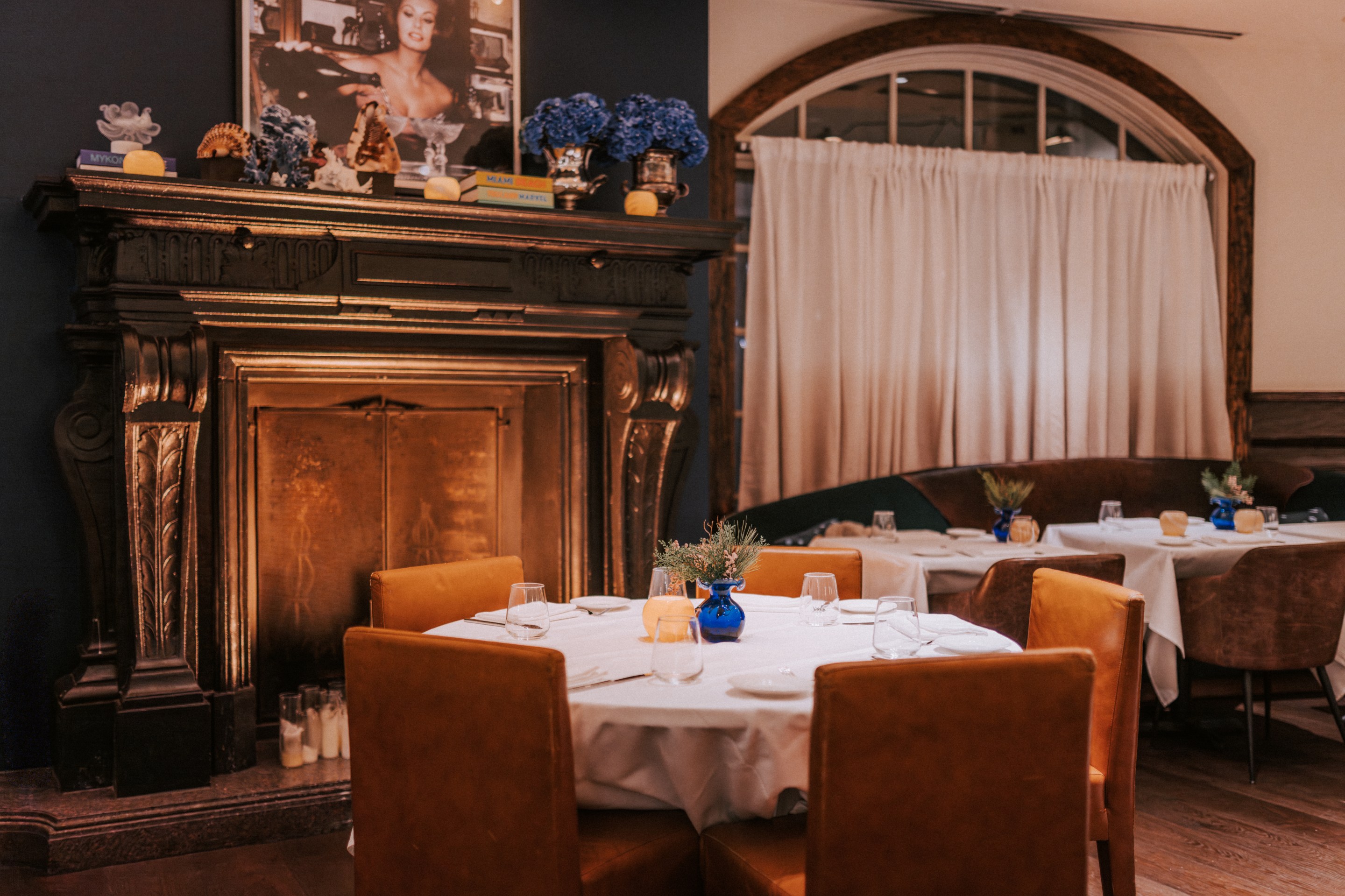 Elegant dining room with fireplace and leather chairs at Marea Aspen.