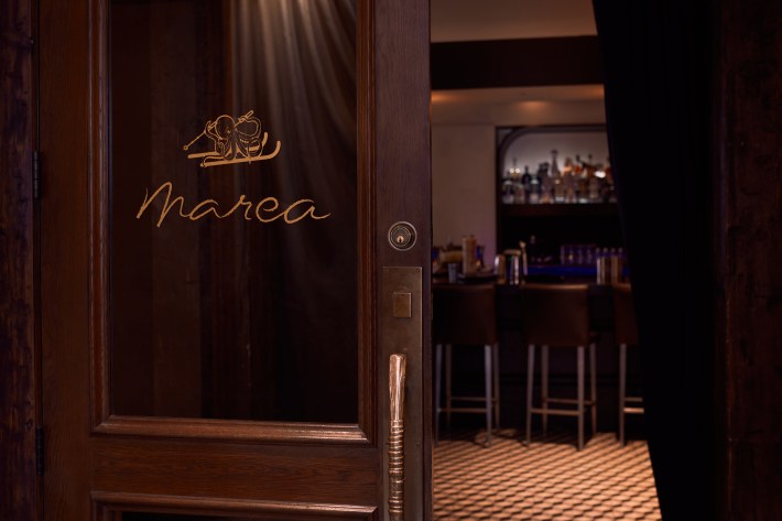 Wooden entrance door with Marea logo leading into the restaurant bar area.