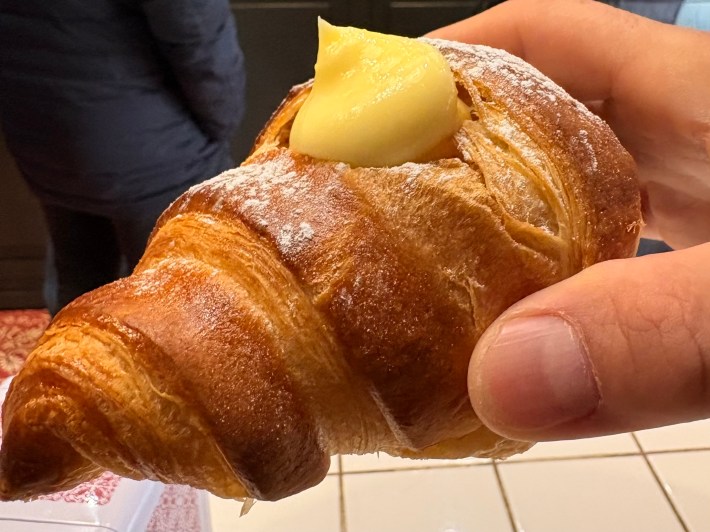 Italian cornetto filled with pastry cream in Milan café