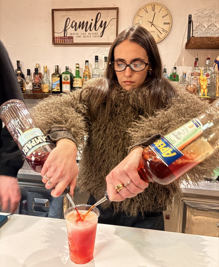 Bartender pouring Campari and Aperol for a spritz in Milan