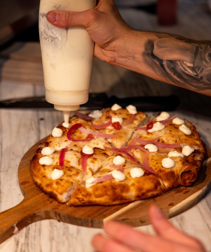 Close up of a pizza topped with mozzarella and pickled onions at Francesco Martucci Miami.