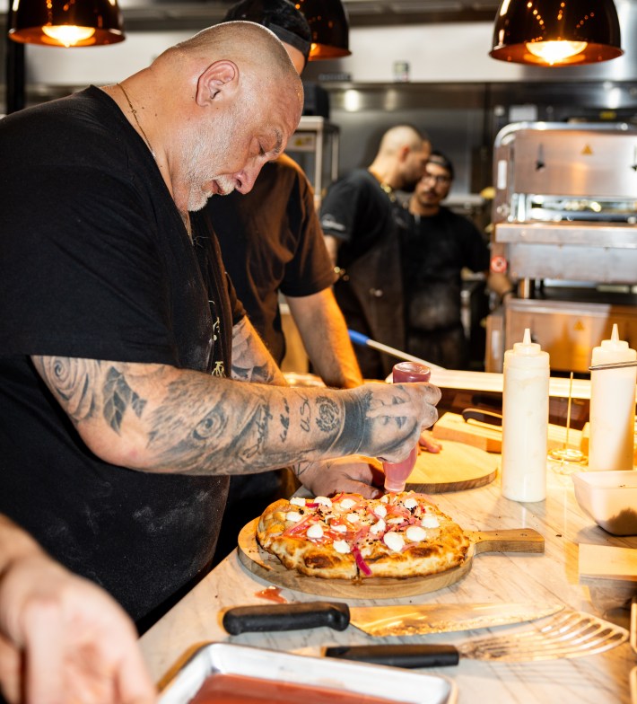Francesco Martucci assembling a pizza with fresh toppings in Miami.