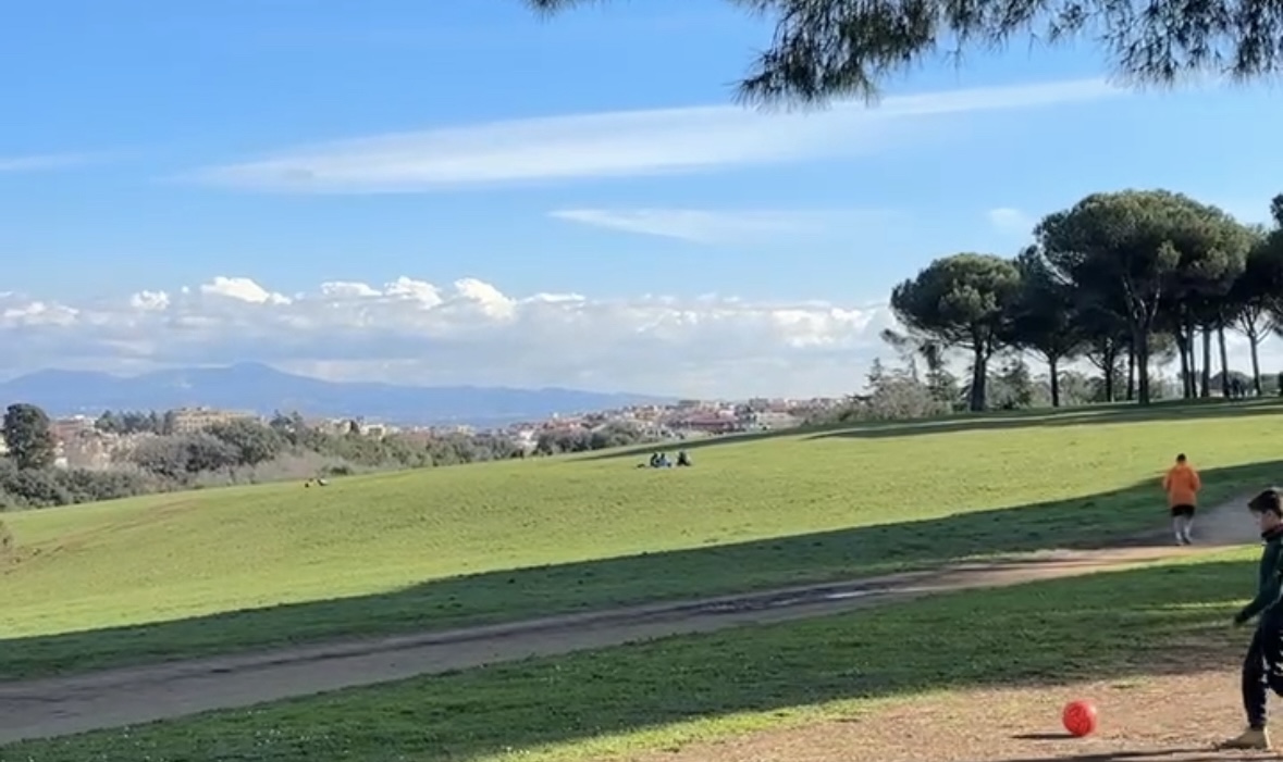 Sweeping green lawn at Villa Pamphili in Monteverde Rome under blue sky