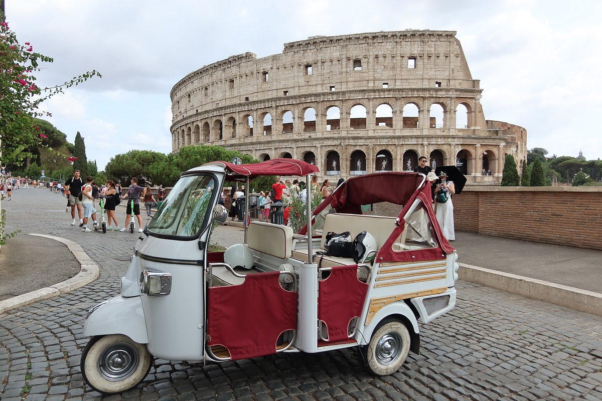Ape Calessino three wheel scooter tour vehicle parked near the Colosseum in Rome