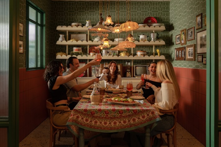 Guests sharing dinner in the intimate Elvira Room surrounded by vintage kitchen décor and warm lighting.