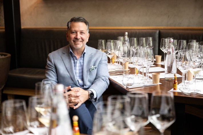 Anthony Giglio standing behind a selection of Italian dishes during a tasting event.