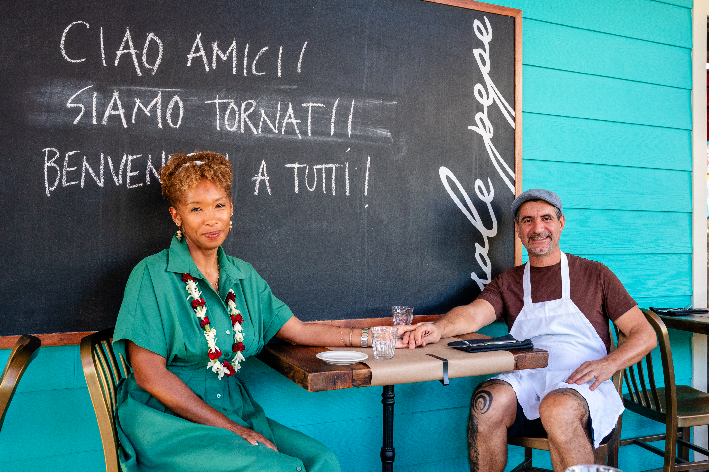 Chef Michele and Qiana at Via! by Sale Pepe, holding hands at an outdoor table