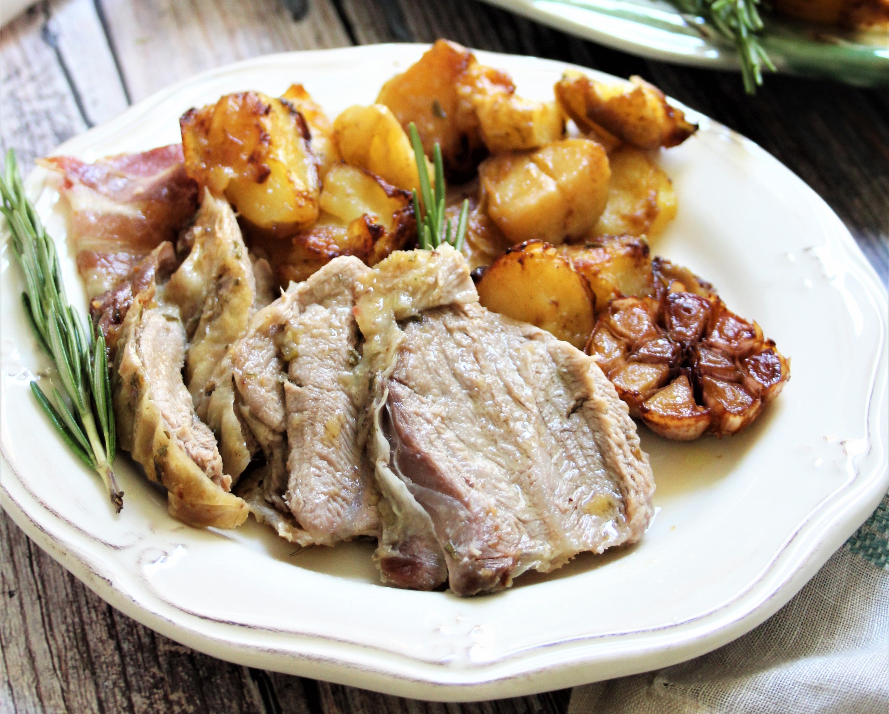 plated roast lamb with potatoes garlic and rosemary