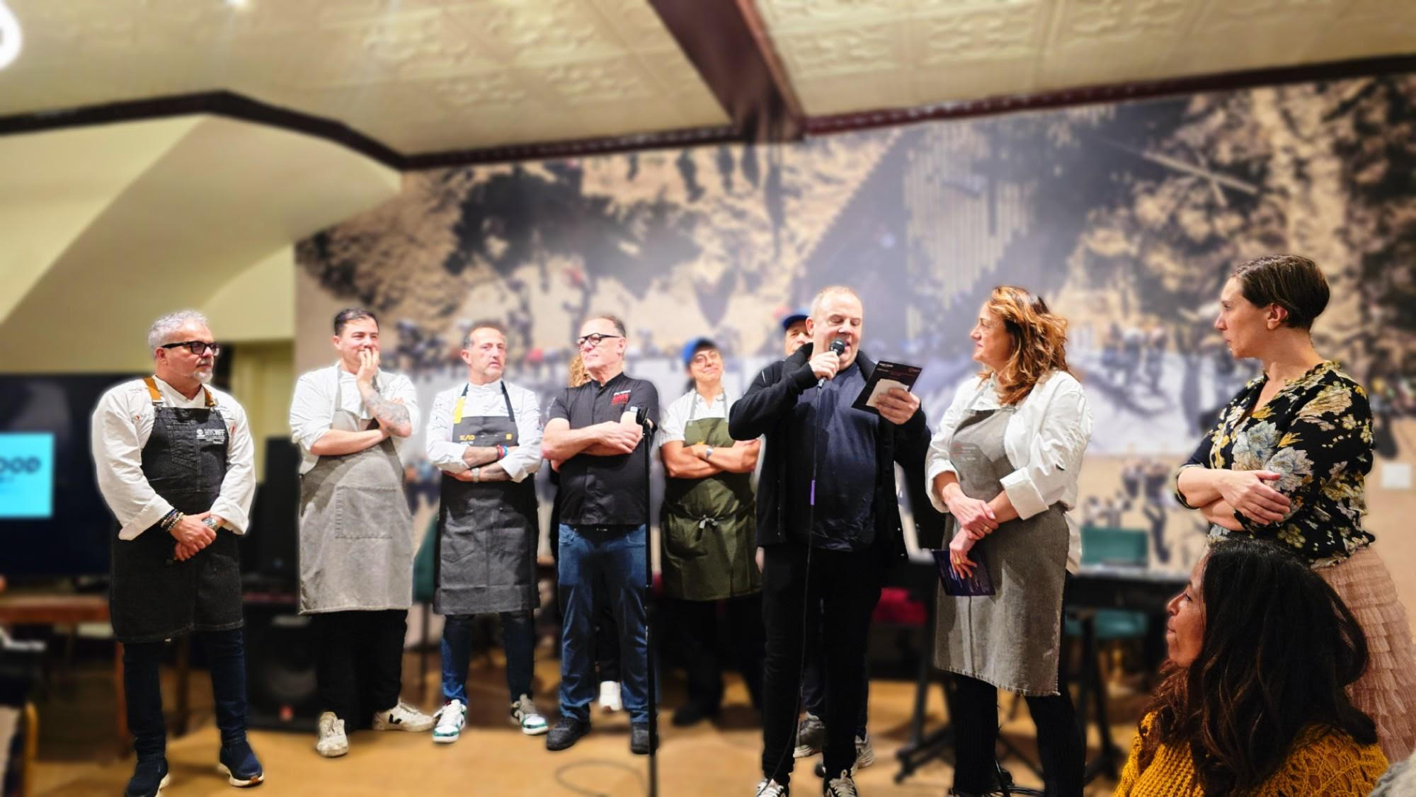 Bob Wilms, Board President of Refettorio Harlem, (center right) addressing Silvia Baldini on stage with all the contributing chefs of the Harlem Loves Italian Food event.