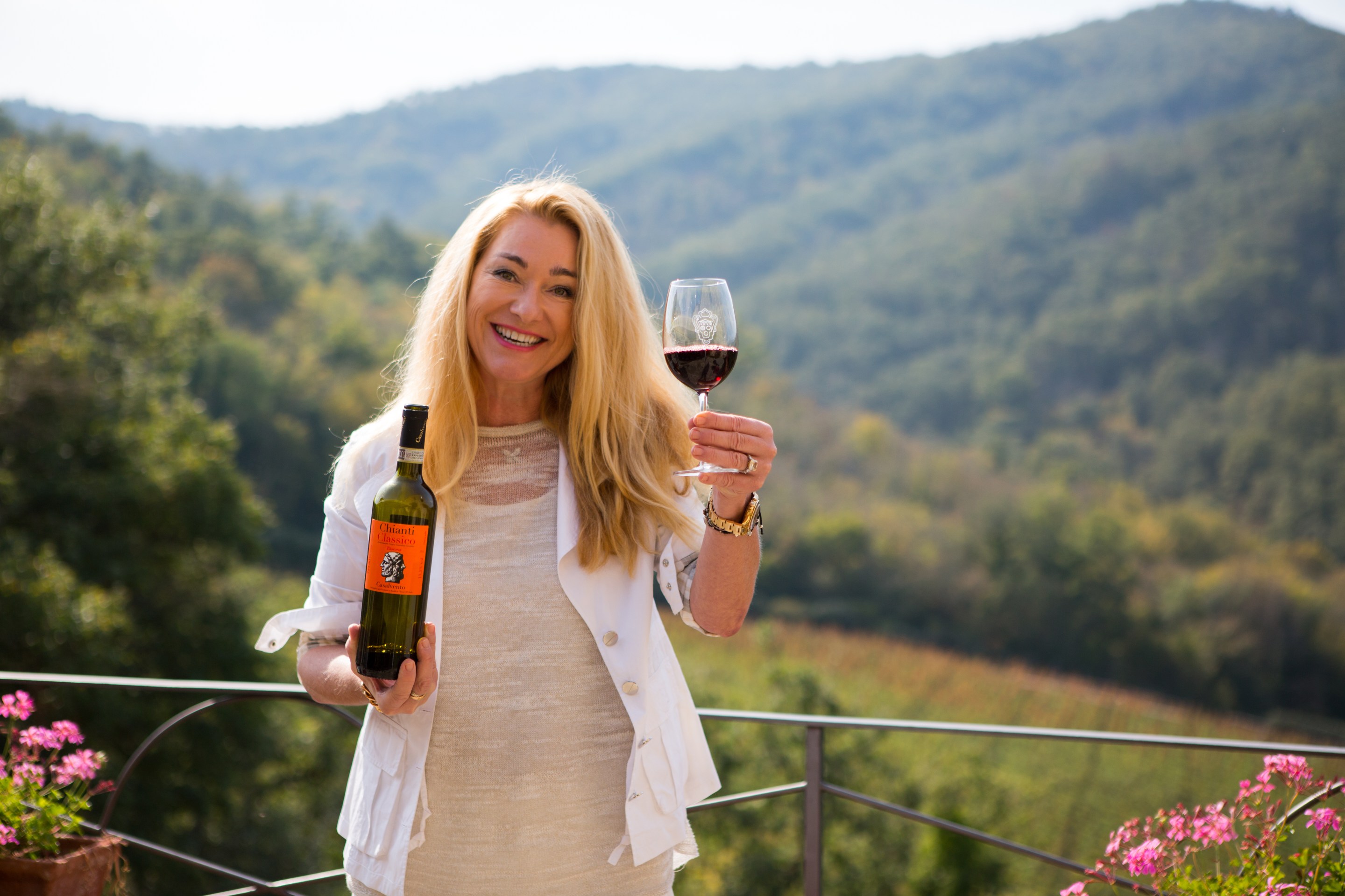 Gudrun Cuillo at Casalvento, overlooking the Chianti Classico hills with a glass of her wine.