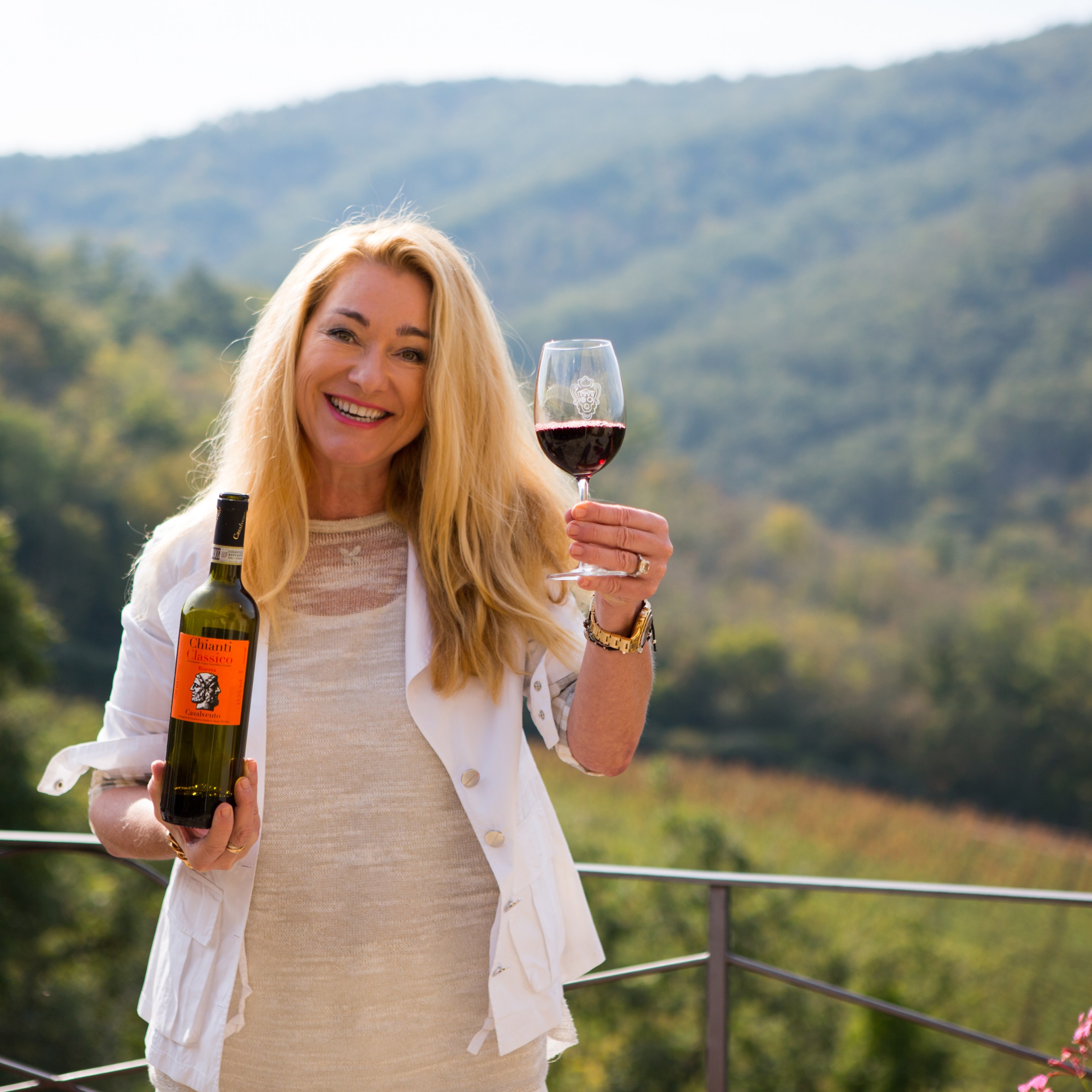 Gudrun Cuillo at Casalvento, overlooking the Chianti Classico hills with a glass of her wine.
