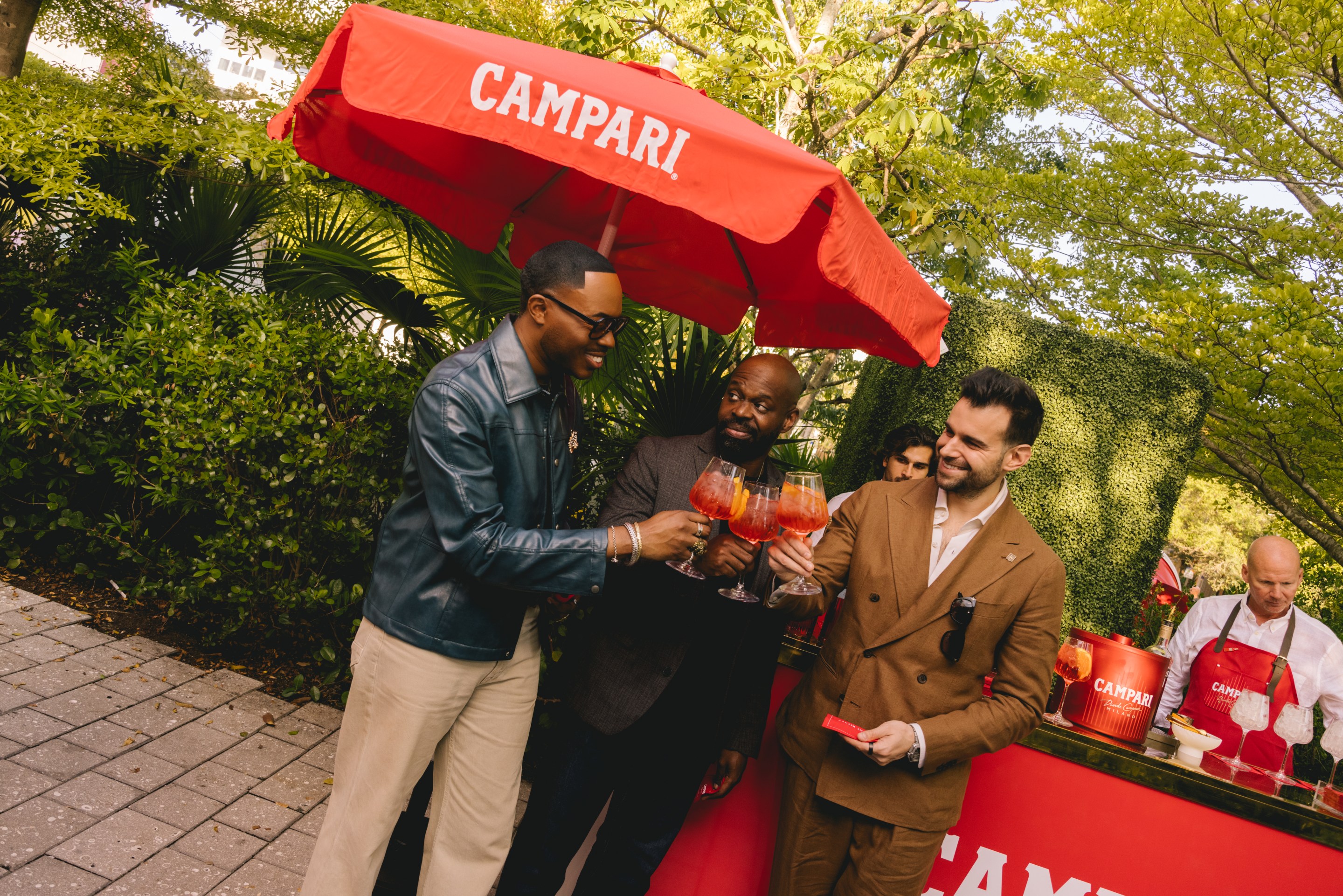 People clinking Campari Spritz cocktails at outdoor aperitivo event