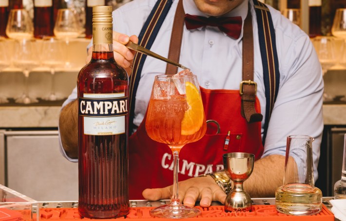 A bartender prepares a classic Campari Spritz.