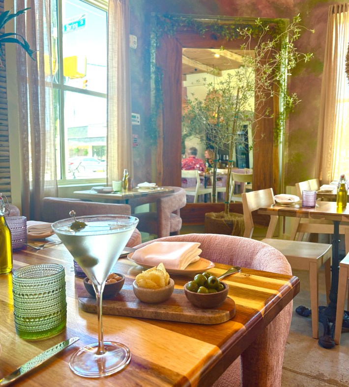 Italian table spread with pasta, seafood, bread, and cocktails