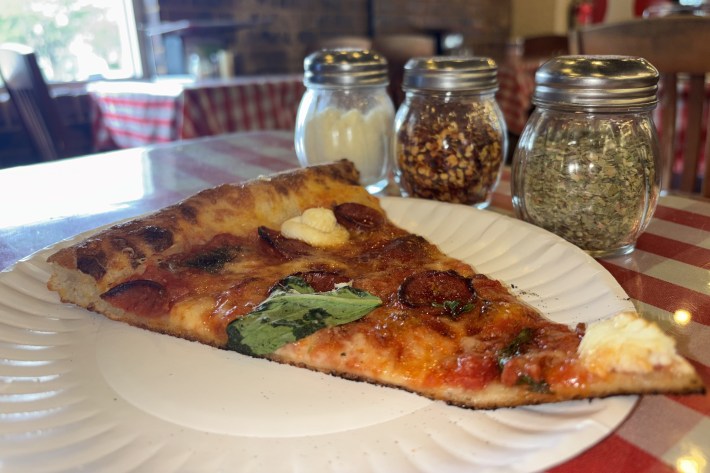 Close-up of a slice of pizza on a plate with toppings