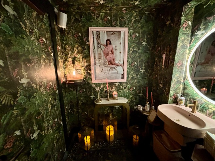 Decorative restaurant bathroom with floral wallpaper and candles