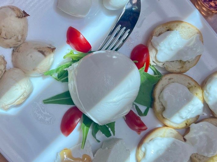 Fresh mozzarella served with tomatoes and bread during a food experience in Sorrento.