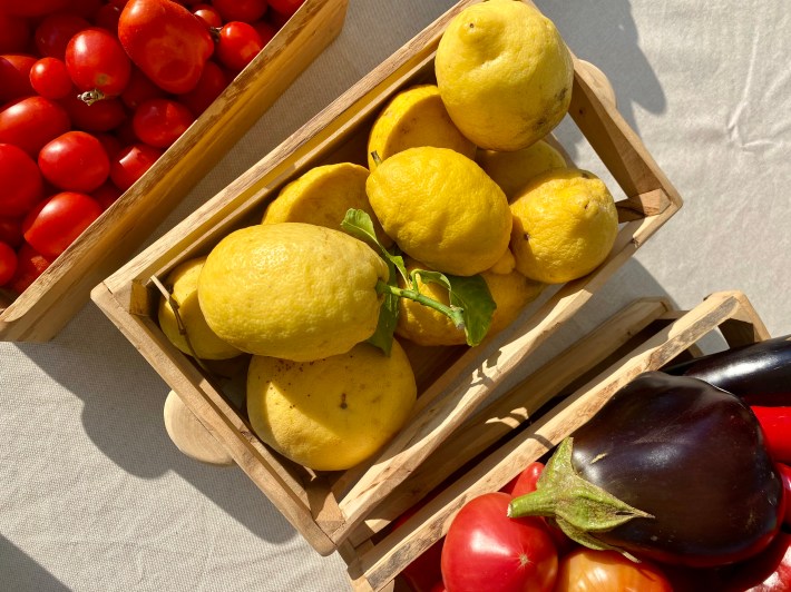 Fresh lemons, tomatoes, and eggplant displayed at a local market in Sorrento.