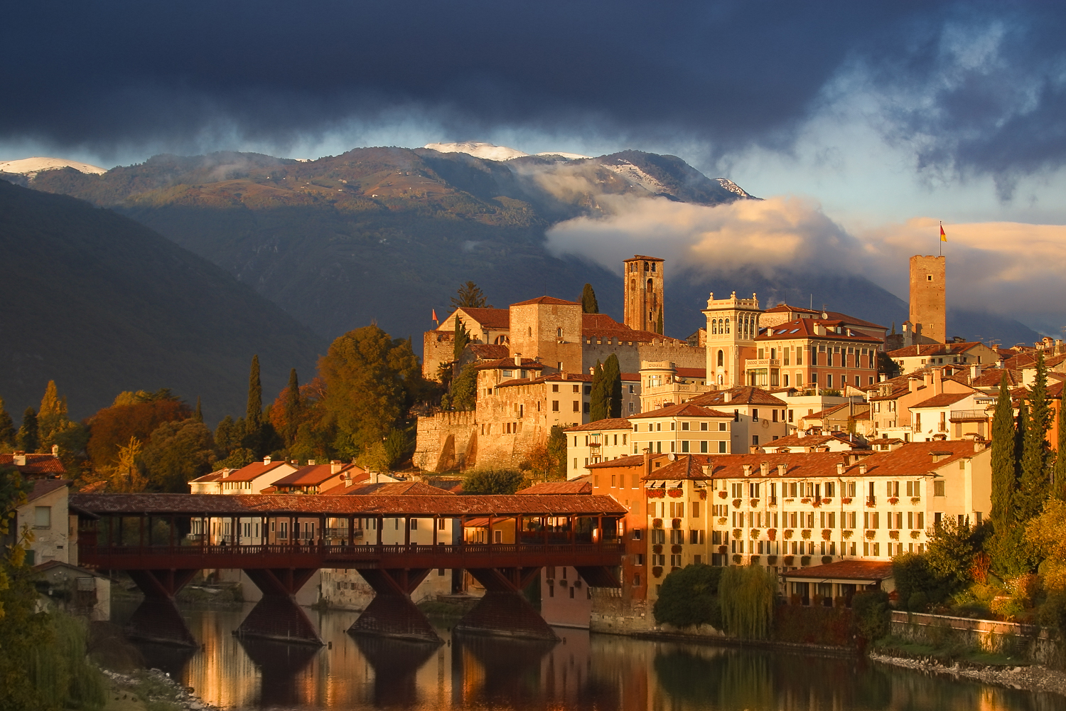 Sunset view of Bassano del Grappa with the covered wooden bridge and mountains in the background