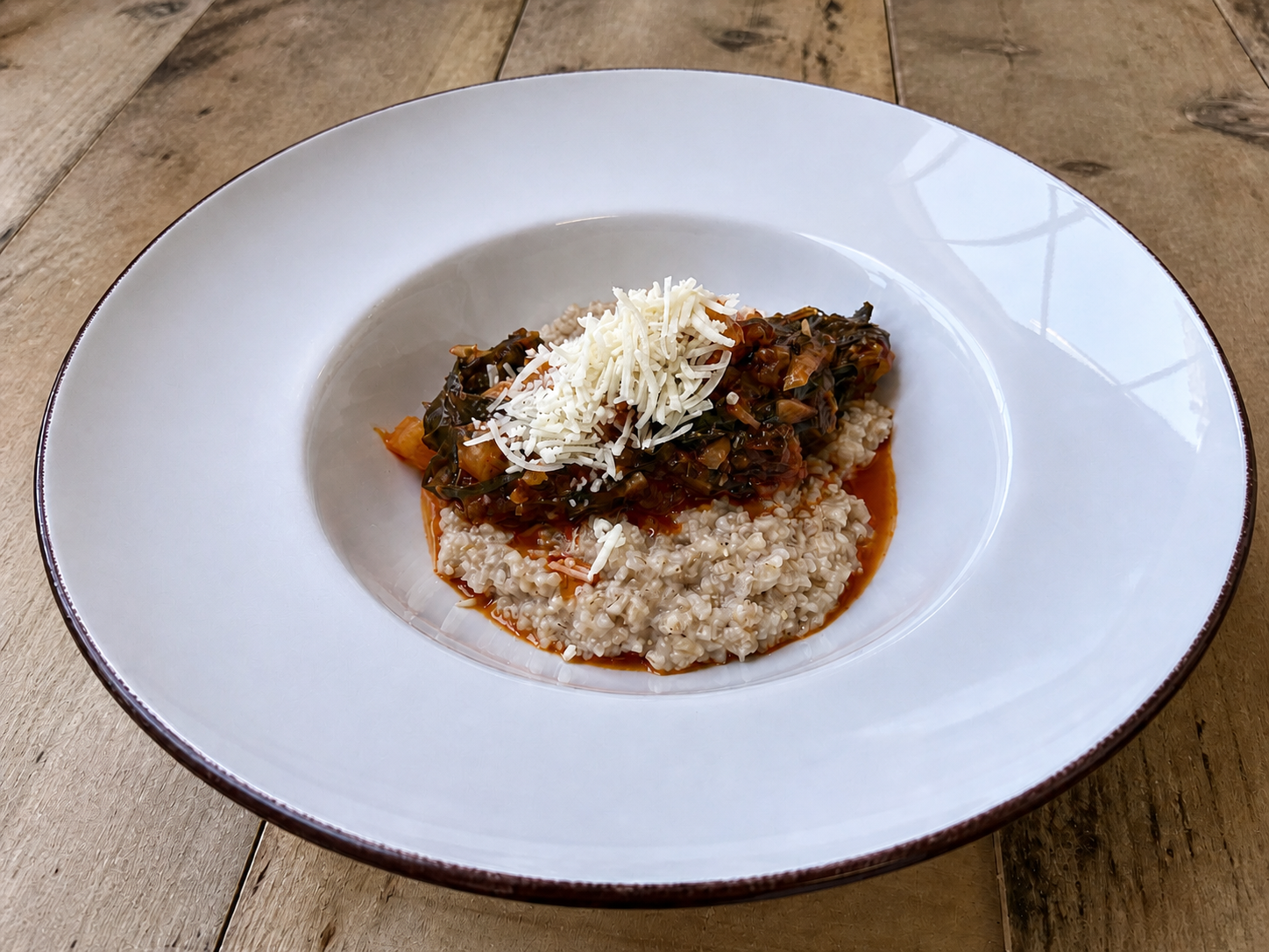 Cuturro plated in a white bowl and topped with cheese