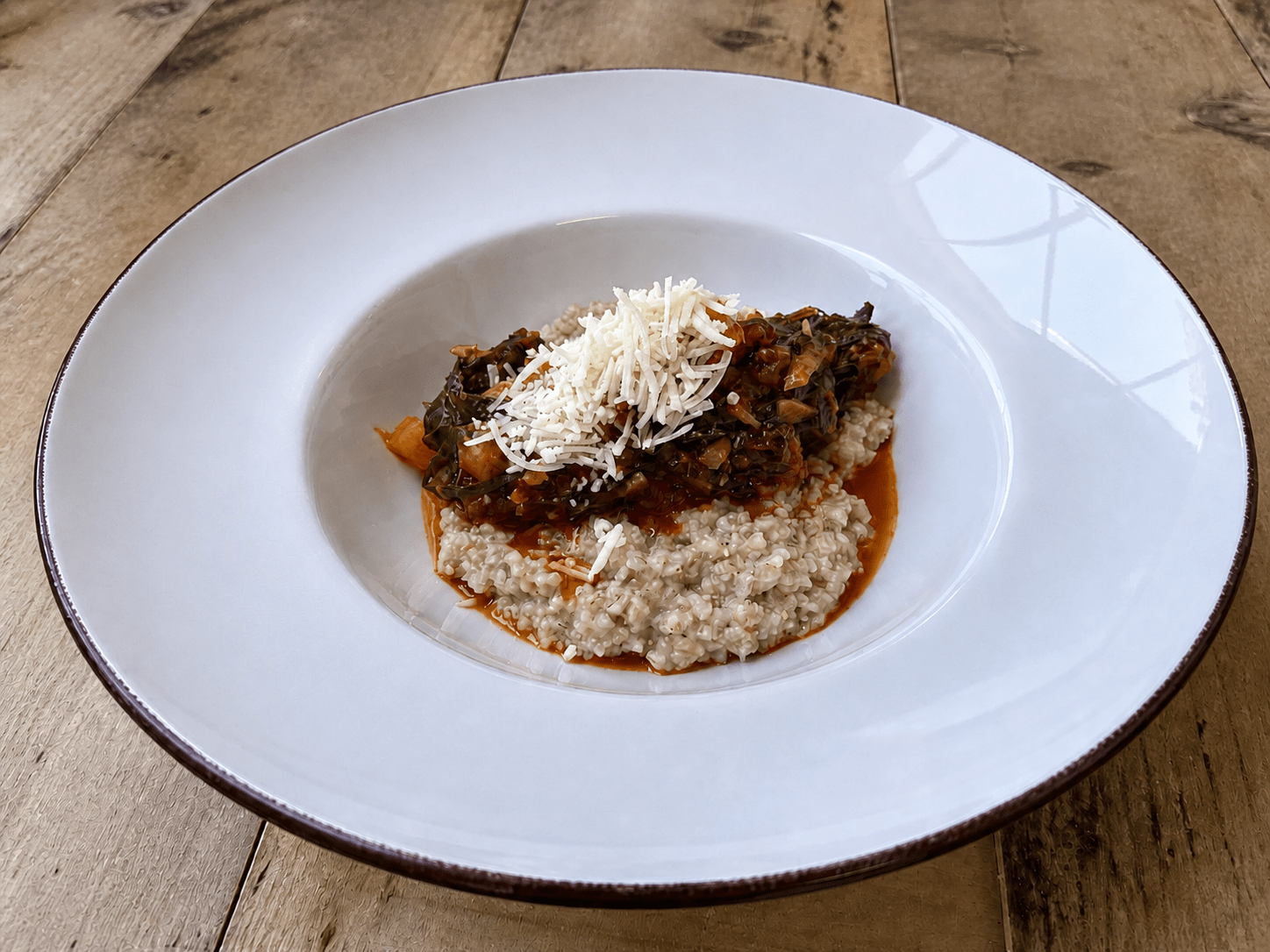 Cuturro plated in a white bowl and topped with cheese