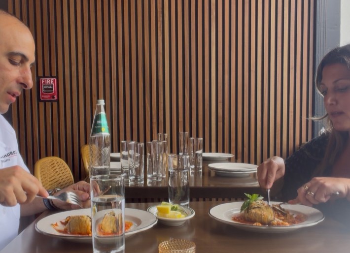 Diners cutting into timballo di anelletti at a restaurant table