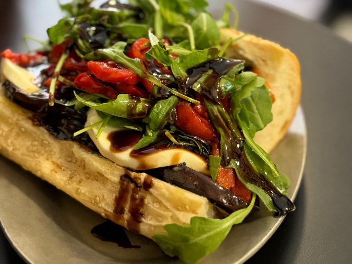 Fried eggplant sandwich from Regina’s Grocery with mozzarella, roasted red peppers, arugula, and balsamic glaze.
