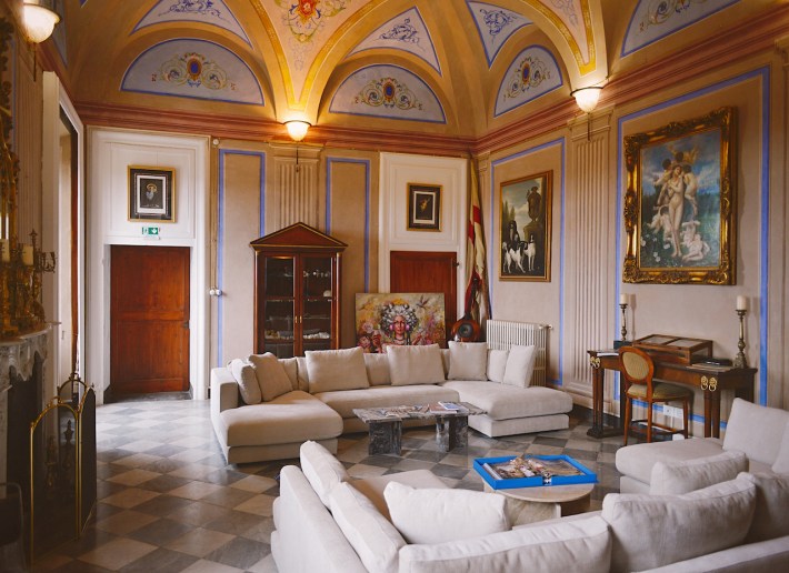 Historic salon at Club Carpeneto featuring vaulted ceilings, artwork, and lounge seating.