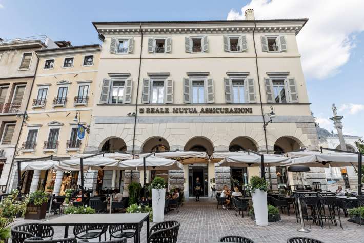 The historic facade of the Udine location overlooks Piazza della Libertà, showcasing the brand's signature approach to prime, central locations.