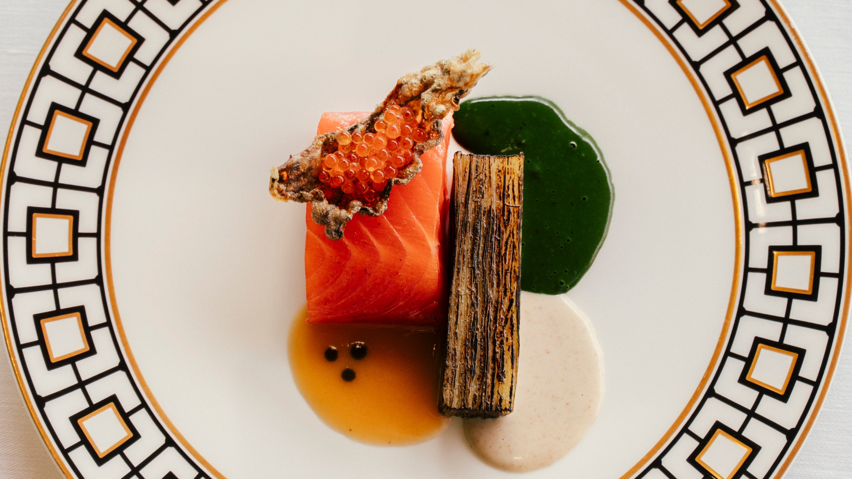 The Iced Trout: Salmon Trout, green apple and horseradish at Lido Palace on a white plate with gold and black square trim.