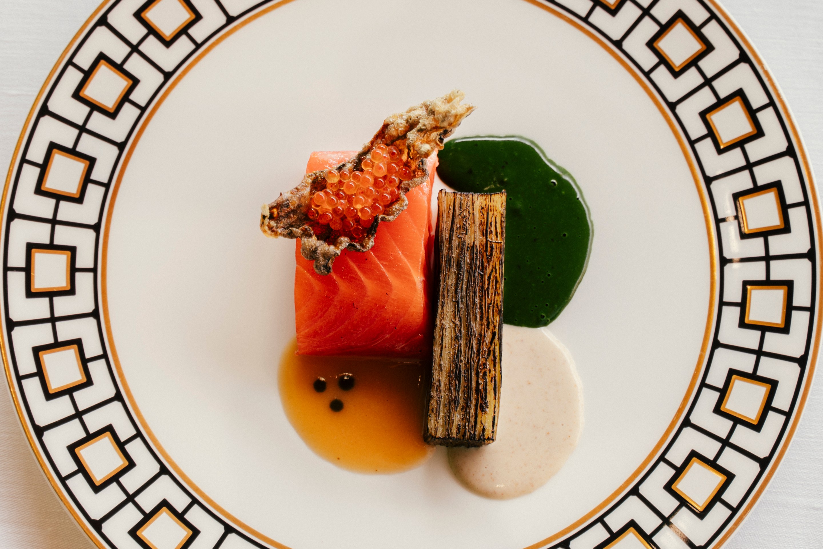 The Iced Trout: Salmon Trout, green apple and horseradish at Lido Palace on a white plate with gold and black square trim.
