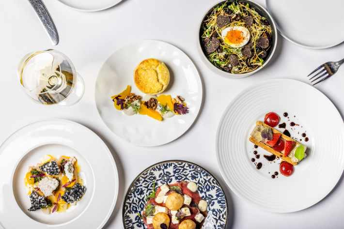 Several plated dishes including pasta, vegetables and dessert at Barolo Grill in Denver.