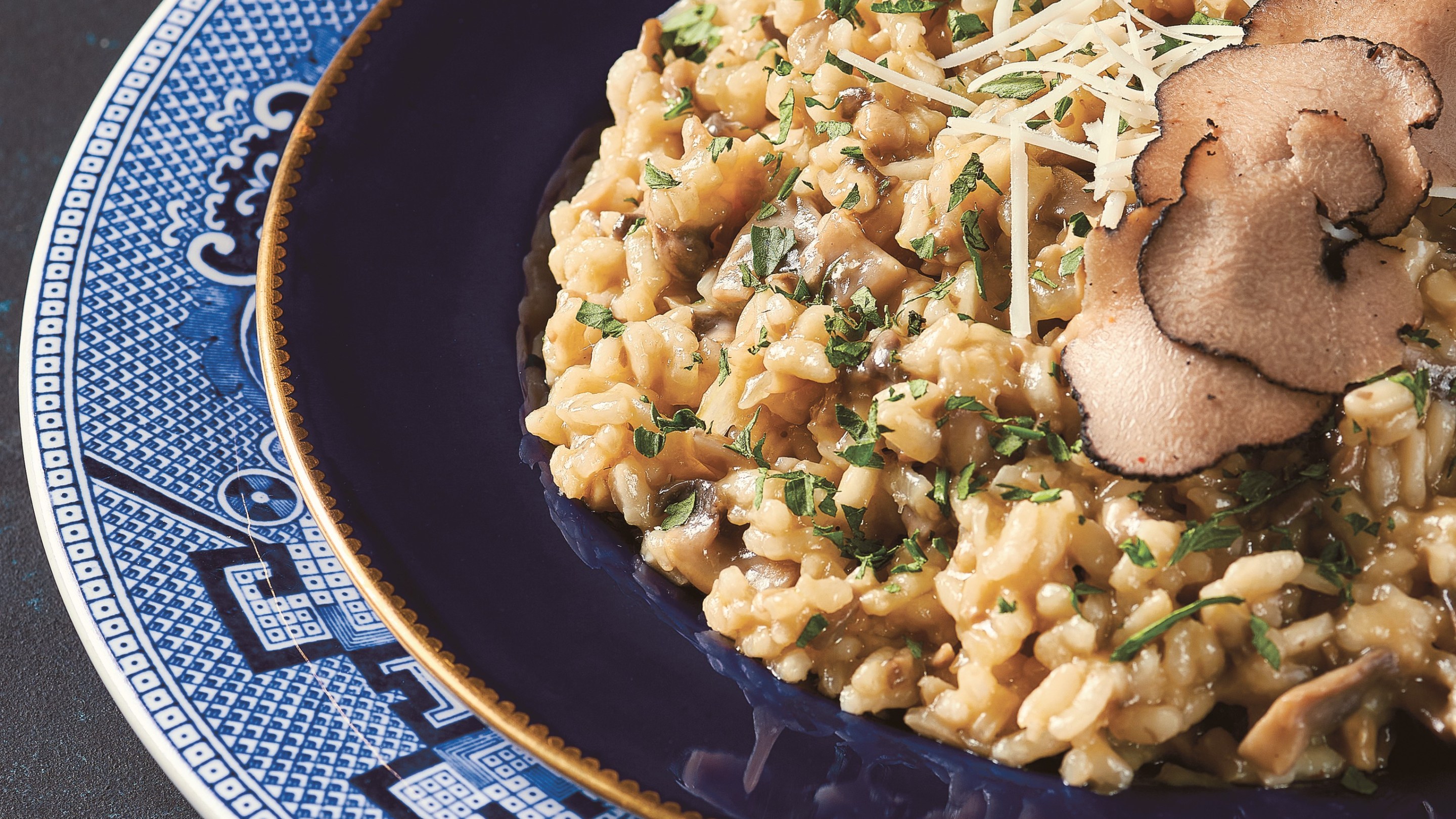 White truffle and mushroom risotto served on a blue plate.