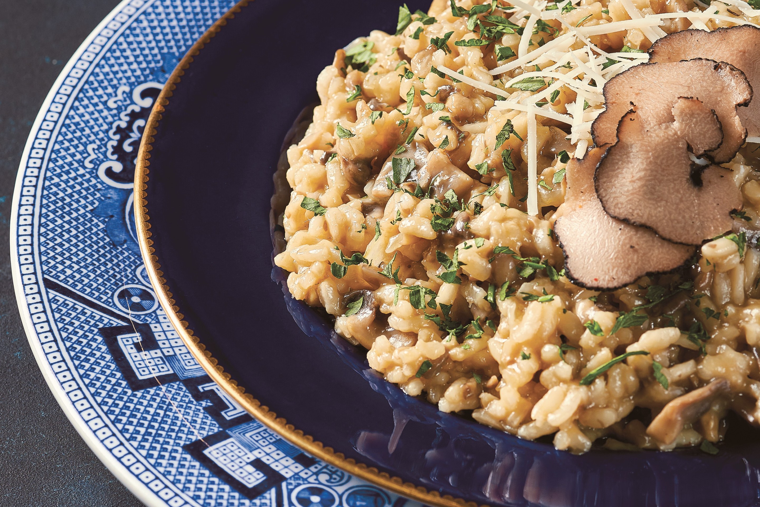White truffle and mushroom risotto served on a blue plate.