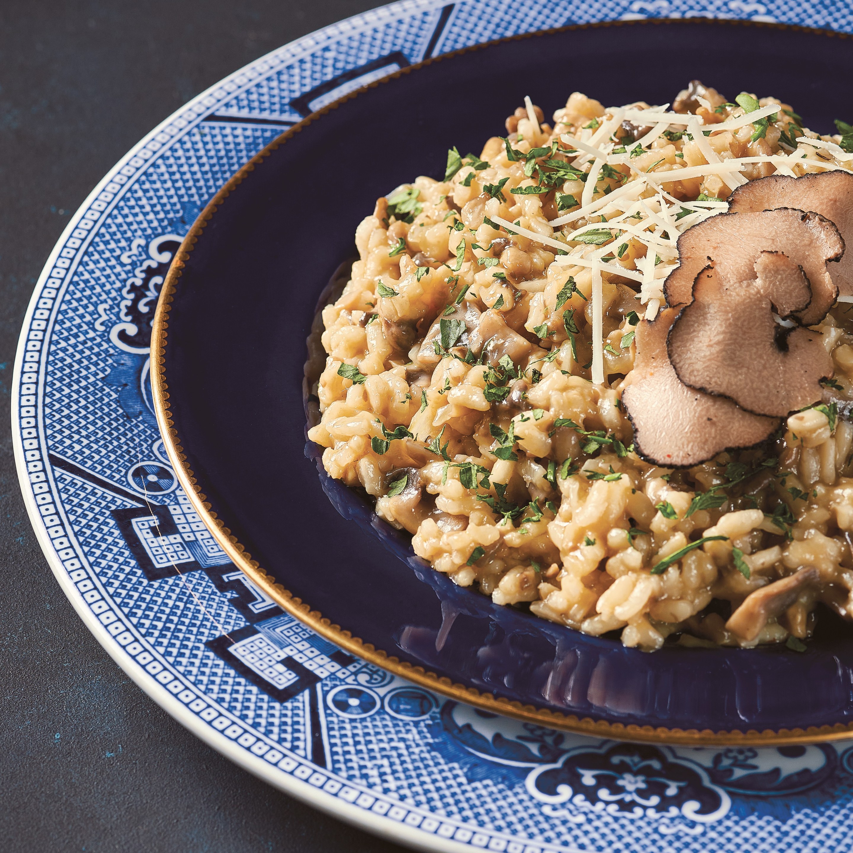 White truffle and mushroom risotto served on a blue plate.