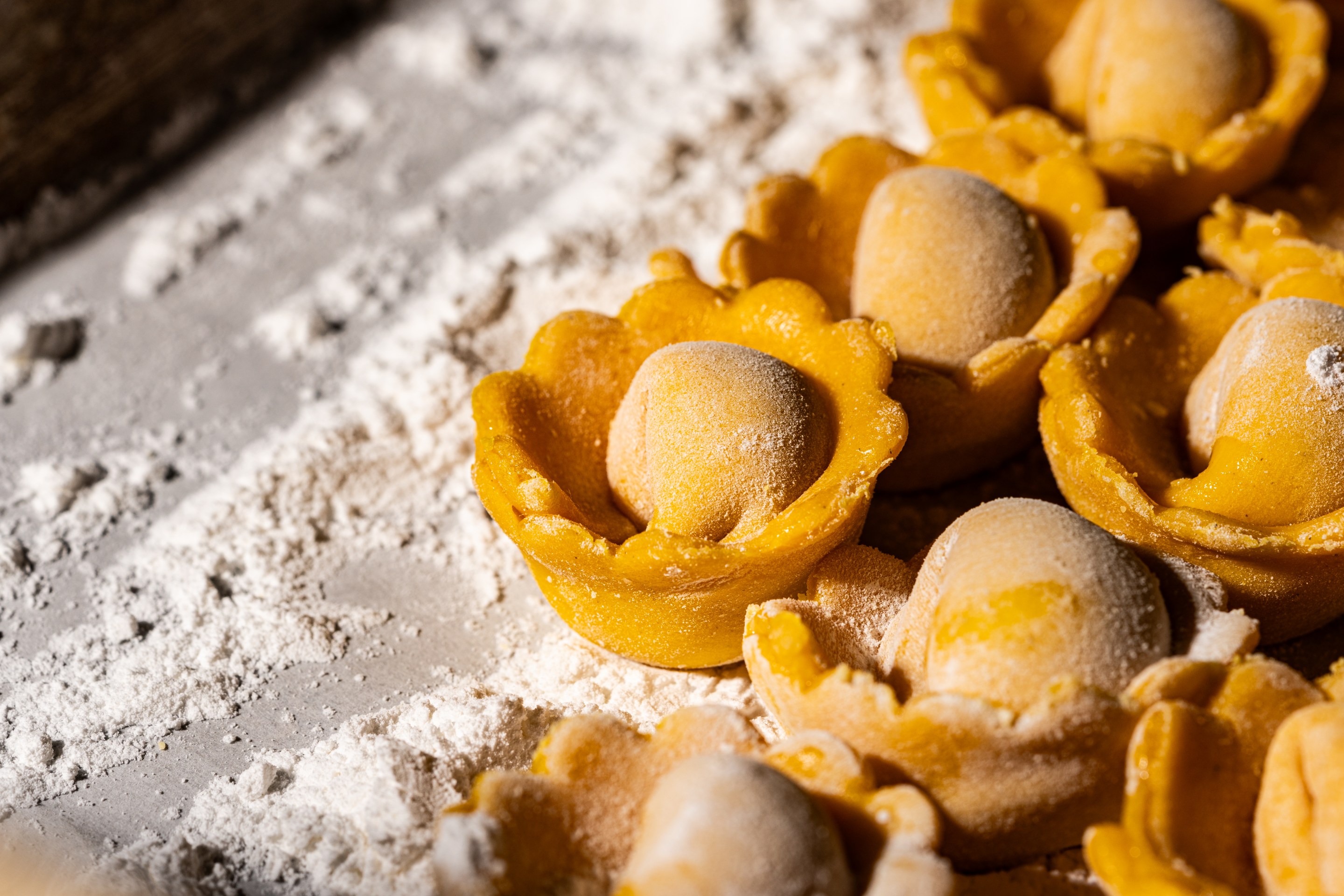 Fresh handmade stuffed pasta rests on a floured work surface at Piccolo MORINI.