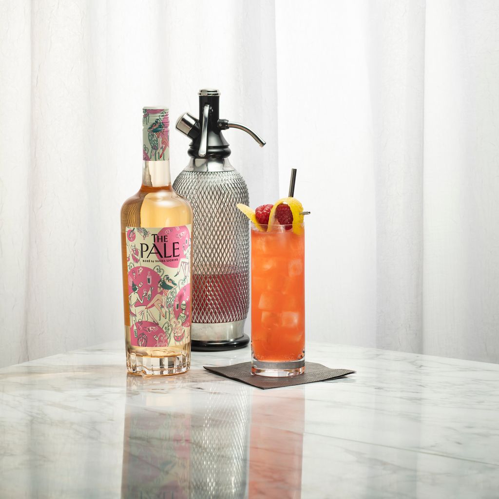 The Pale Rosé Spritz cocktail served over ice beside a bottle of The Pale Rosé.
