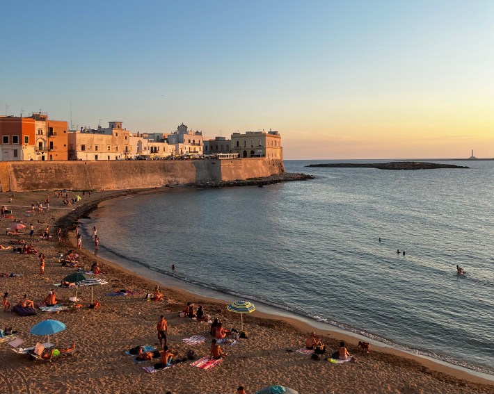 Beach and historic waterfront at sunset in Gallipoli, Puglia