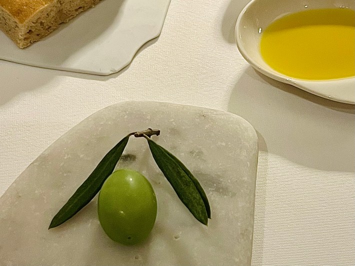 Olive-shaped amuse-bouche served with extra virgin olive oil.