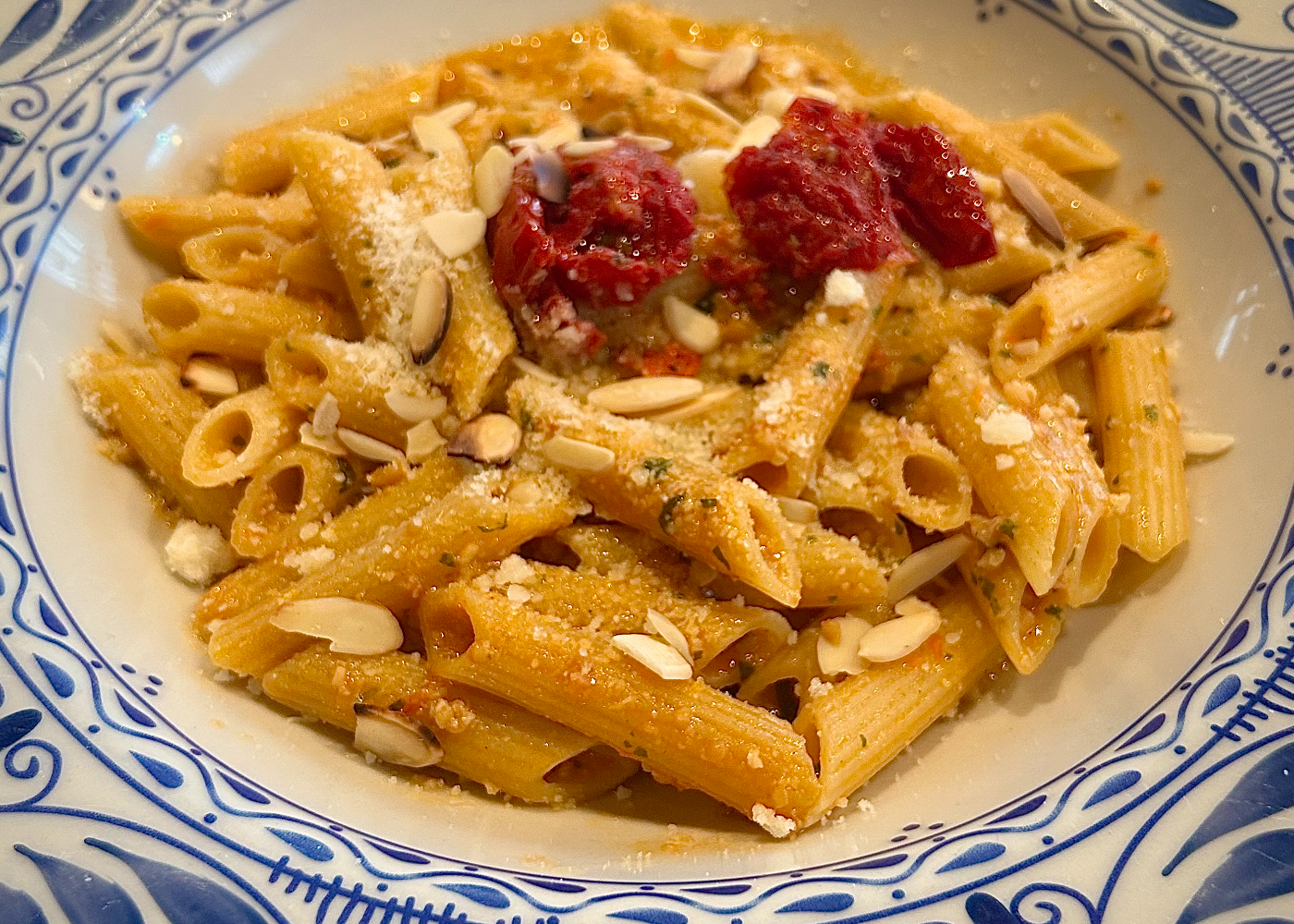 Bowl of pesto alla Trapanese made with cherry tomatoes, sundried tomatoes, toasted almonds, basil, and Pecorino cheese