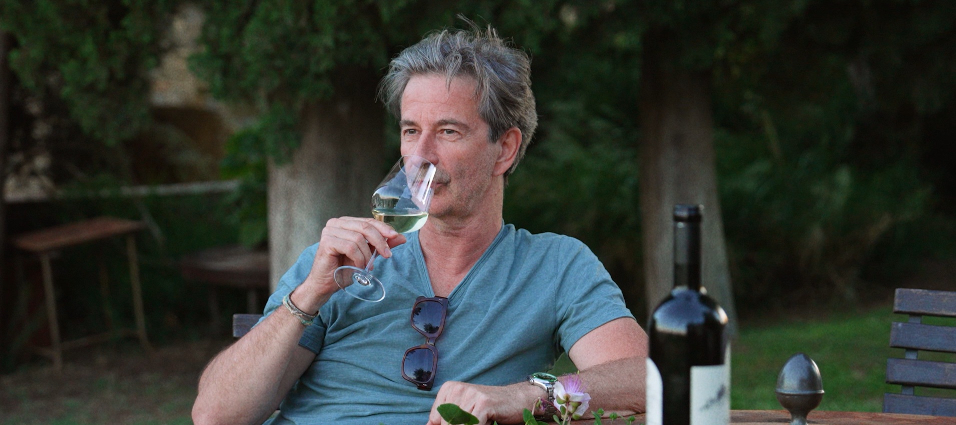 Laurent Vernhes holding a glass of wine at a winery in Tuscany.