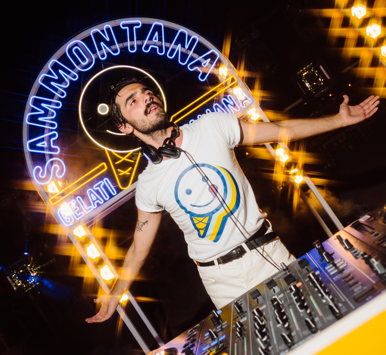 DJ performing beneath a glowing Sammontana neon sign